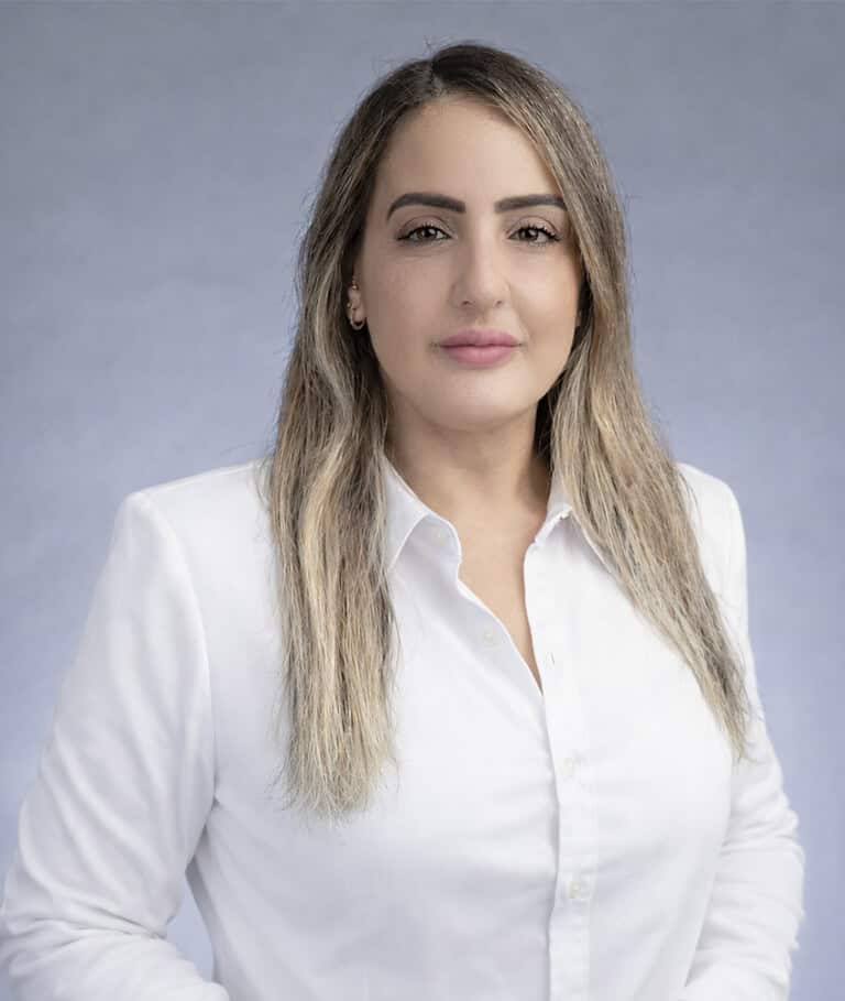 A professional woman with a confident expression, dressed in a white shirt, representing expertise i.